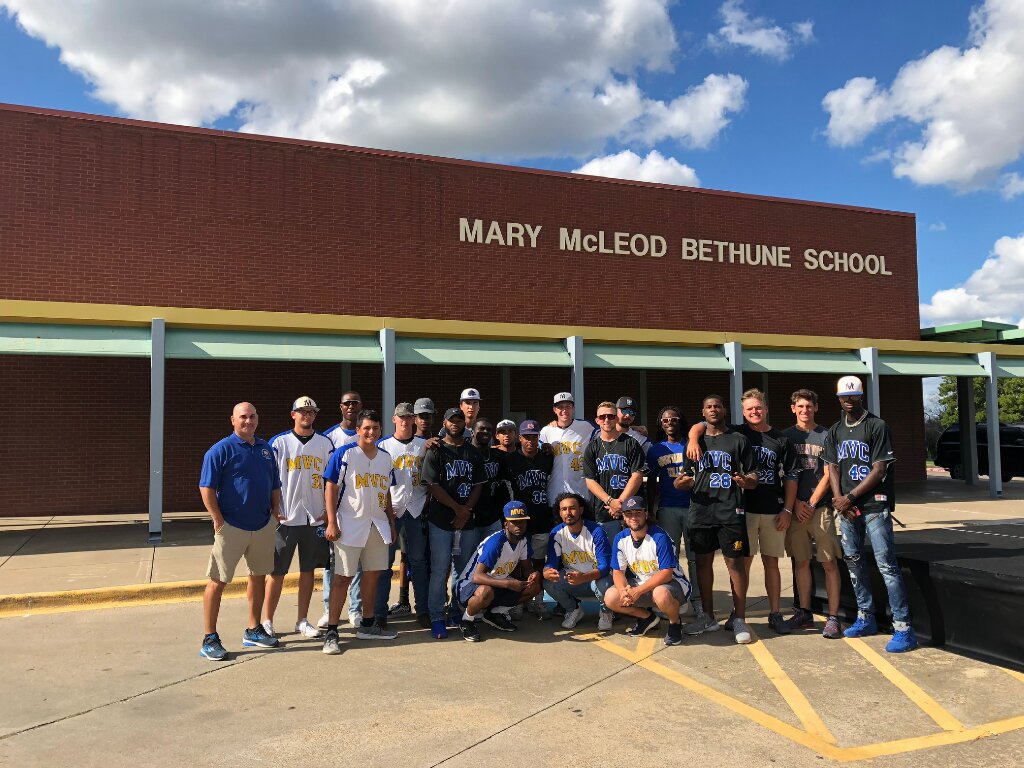 Baseball team poses in front of Mary McLeod Bethune School before helping with Fall Festival.